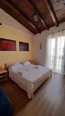 a bedroom with a large bed and two windows at Guest House Beati Paoli in Palermo
