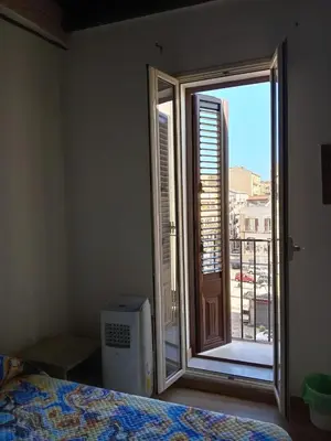 a bedroom with a window with a view of a balcony at Guest House Beati Paoli in Palermo