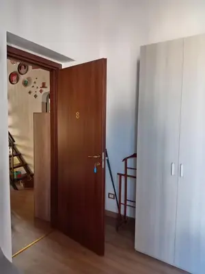 an empty room with a wooden door and a hallway at Guest House Beati Paoli in Palermo