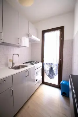 a white kitchen with a sink and a window at Caleidoscopica Bahlara Ballarò in Palermo