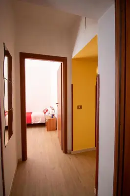 a hallway with a room with a bed and a yellow door at Caleidoscopica Bahlara Ballarò in Palermo