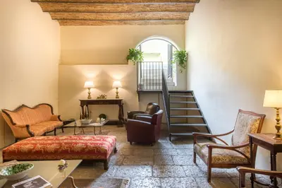a living room with a staircase and a couch and chairs at Casa d'arte Ugdulena con Piscina e Terrazza by Wonderful Italy in Palermo