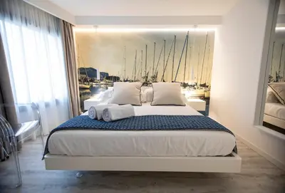 a bedroom with a bed with a painting on the wall at Suite Quaroni in Palermo