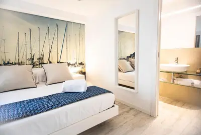 a bedroom with a bed with a painting of boats at Suite Quaroni in Palermo