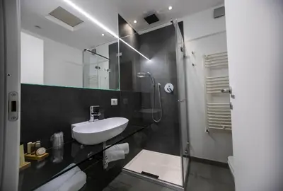 a black and white bathroom with a sink and a shower at Suite Quaroni in Palermo