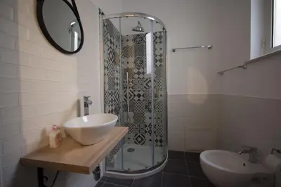 a bathroom with a shower and a sink and a mirror at Il Genoardo Della Zisa in Palermo