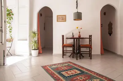 a dining room with a table and chairs and a rug at Ai Mori in Palermo