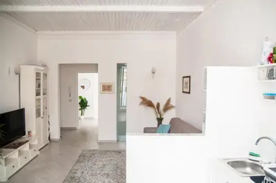 a living room with white walls and a tv at Ai Mori in Palermo