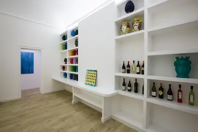 a room with white shelves filled with wine bottles at Palermo In Suite Aparthotel in Palermo