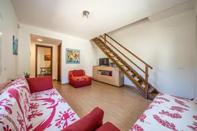 a living room with a couch and a staircase at Le Casette Di Maria Pia in Mondello