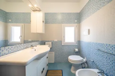 a bathroom with a sink and a toilet at Le Casette Di Maria Pia in Mondello