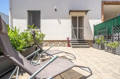 a pair of chairs sitting on the patio of a house at Le Casette Di Maria Pia in Mondello