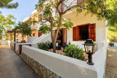 a white house with a street light in front of it at Residence Smeraldo in San Vito lo Capo