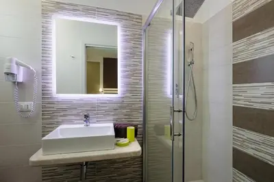 a bathroom with a sink and a shower with a mirror at Affittacamere Sirius in San Vito lo Capo