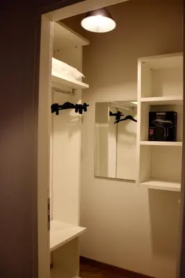 a room with white shelves and a mirror at WelcHomeLoft in Palermo