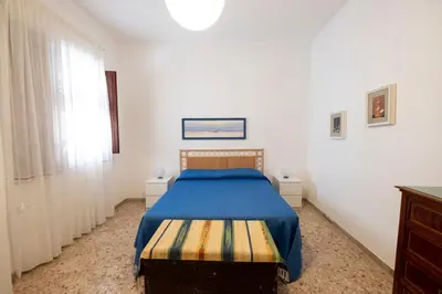a bedroom with a bed with a blue blanket at Casa Lisa a due passi dal mare con ampio giardino in San Vito lo Capo