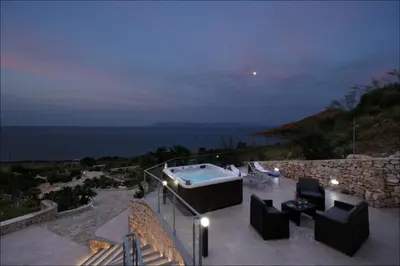 a patio with a hot tub and a stone wall at Villa Antonia - Vasca Idromassaggio Terrazza Vista Mare in San Vito lo Capo