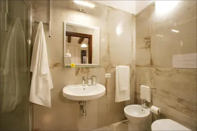 a bathroom with a sink and a toilet and a mirror at Villa Antonia - Vasca Idromassaggio Terrazza Vista Mare in San Vito lo Capo
