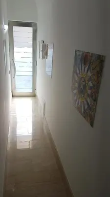 a hallway with a painting hanging on a wall at GíeffeHOUSE in Terrasini