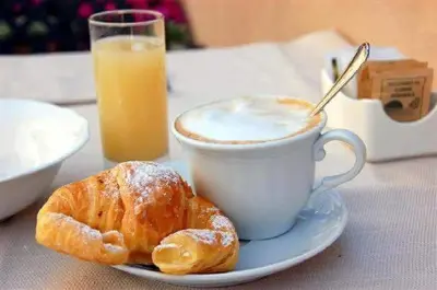 a plate with a cup of coffee and a pastry at GíeffeHOUSE in Terrasini