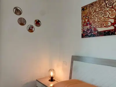 a bedroom with a bed and a table with a lamp at Granatelli Holiday Home in Altavilla Milicia