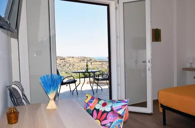 a room with a table and a view of a patio at Granatelli Holiday Home in Altavilla Milicia