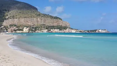 a view of a beach with a mountain in the background at DaRiMaPa House in Mondello
