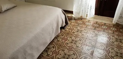 a bedroom with a bed and a tile floor at DE MEO Guest House in Castellammare del Golfo