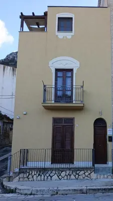 a building with a balcony on the side of it at DE MEO Guest House in Castellammare del Golfo