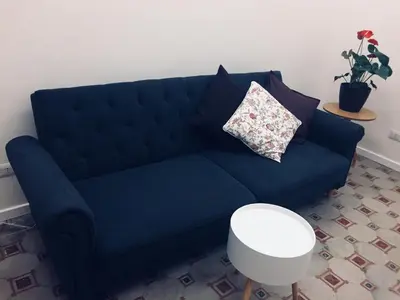 a blue couch with a pillow on it in a living room at CLUVERIO11 LUXURY APARTMENT in Palermo
