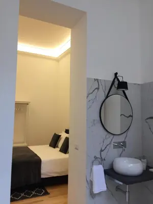 a bathroom with a sink and a bed and a mirror at CLUVERIO11 LUXURY APARTMENT in Palermo