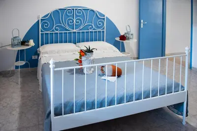a blue and white bedroom with a bed with a blue headboard at L' Arena Suite - Sicilian style 140 mq flat with balcony and Arena seeview in Castellammare del Golfo