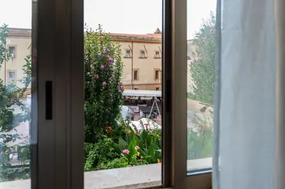 an open window with a view of a garden at L' Arena Suite - Sicilian style 140 mq flat with balcony and Arena seeview in Castellammare del Golfo
