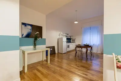 a kitchen and living room with a table and a refrigerator at Casetta Allegra in Palermo