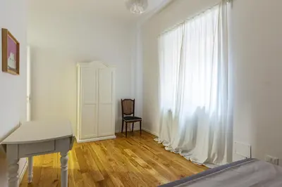 a bedroom with a bed and a desk and a window at Casetta Allegra in Palermo