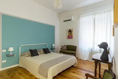 a bedroom with a bed and a chair at Casetta Allegra in Palermo
