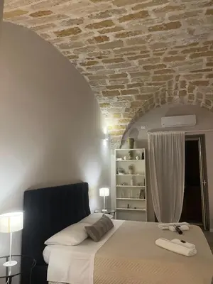 a bedroom with a bed and a brick wall at Appartamento Valverde in Palermo