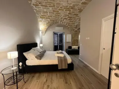 a bedroom with a bed and a brick wall at Appartamento Valverde in Palermo