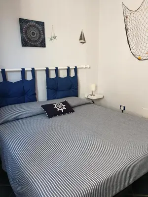 a bedroom with a bed with blue and white stripes at Casa Maro' in Palermo