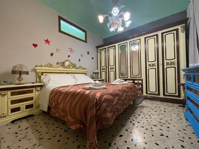 a bedroom with a large bed and a chandelier at Big Mom House in Palermo