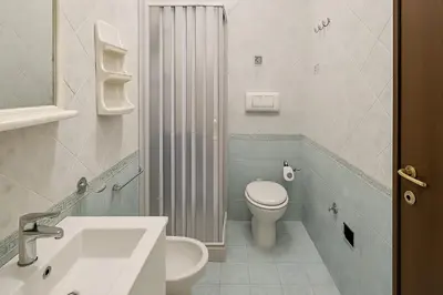 a white bathroom with a toilet and a sink at Appartamenti Penelope in Mondello