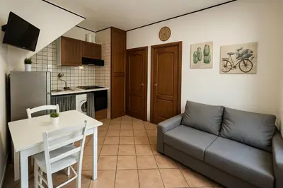 a living room with a couch and a table and a kitchen at Appartamenti Penelope in Mondello