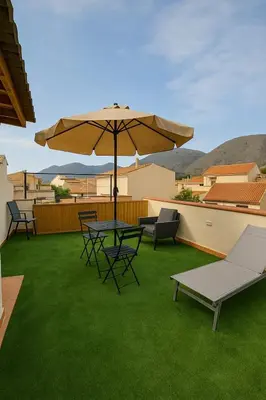 a patio with a table and chairs and an umbrella at Appartamenti Penelope in Mondello