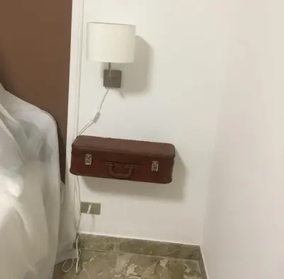 a brown suitcase on a wall next to a bed at Alter Ego in Lascari