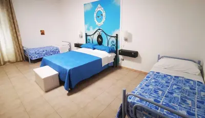 a bedroom with two beds with blue and white at Alter Ego in Lascari