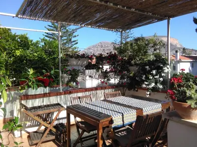 a patio with a table and chairs and flowers at La stanza di Angi a Mondello in Palermo
