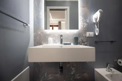 a bathroom with a white sink and a mirror at Room & Breakfast Aloe in San Vito lo Capo