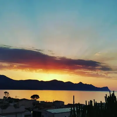a sunset over the water with mountains in the background at Casa Vacanze Aurora Boreale in Alcamo Marina