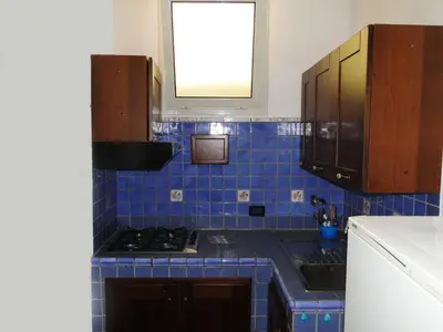 a blue tiled kitchen with a stove and a sink at Appartamenti Cavarretta Seminterrati in Mondello