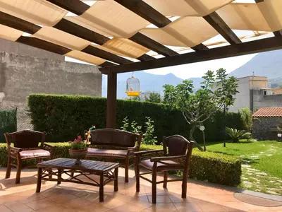 a patio with chairs and a table under a pergola at Cappuccini Green Relax in Carini